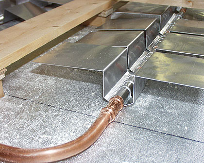 detailaufnahme der aufgesteckten aluminium-waermeverteiler und verpressung des kupferrohres